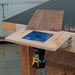 Woodworking router table with a router attached on a workshop background