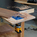 Woodworking router table with a piece of wood being routed on a workshop bench.